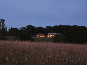 the brick barn, dusk photo of house across grass fields